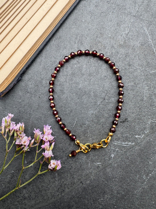 Garnet (January birthstone) faceted round stone, gold metal, bracelet