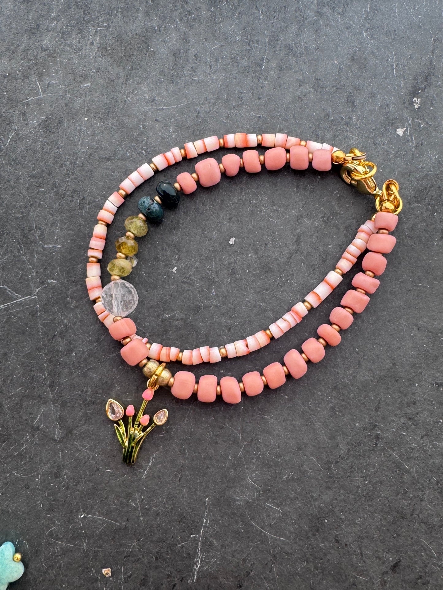 Pink shell, Java glass, quartz, peridot stone, gold metal bracelet.