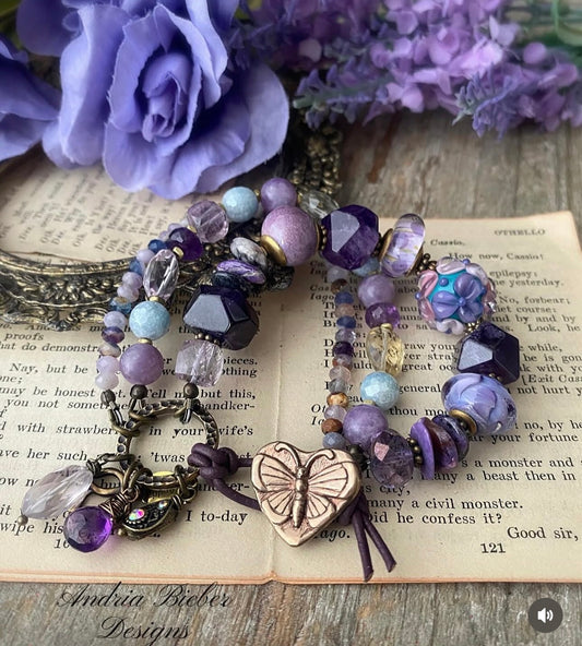 lampwork glass, 
Purple Stichtite, aquamarine, faceted green amethyst, fluorite stone, purple oyster, and bronze butterfly metal button.