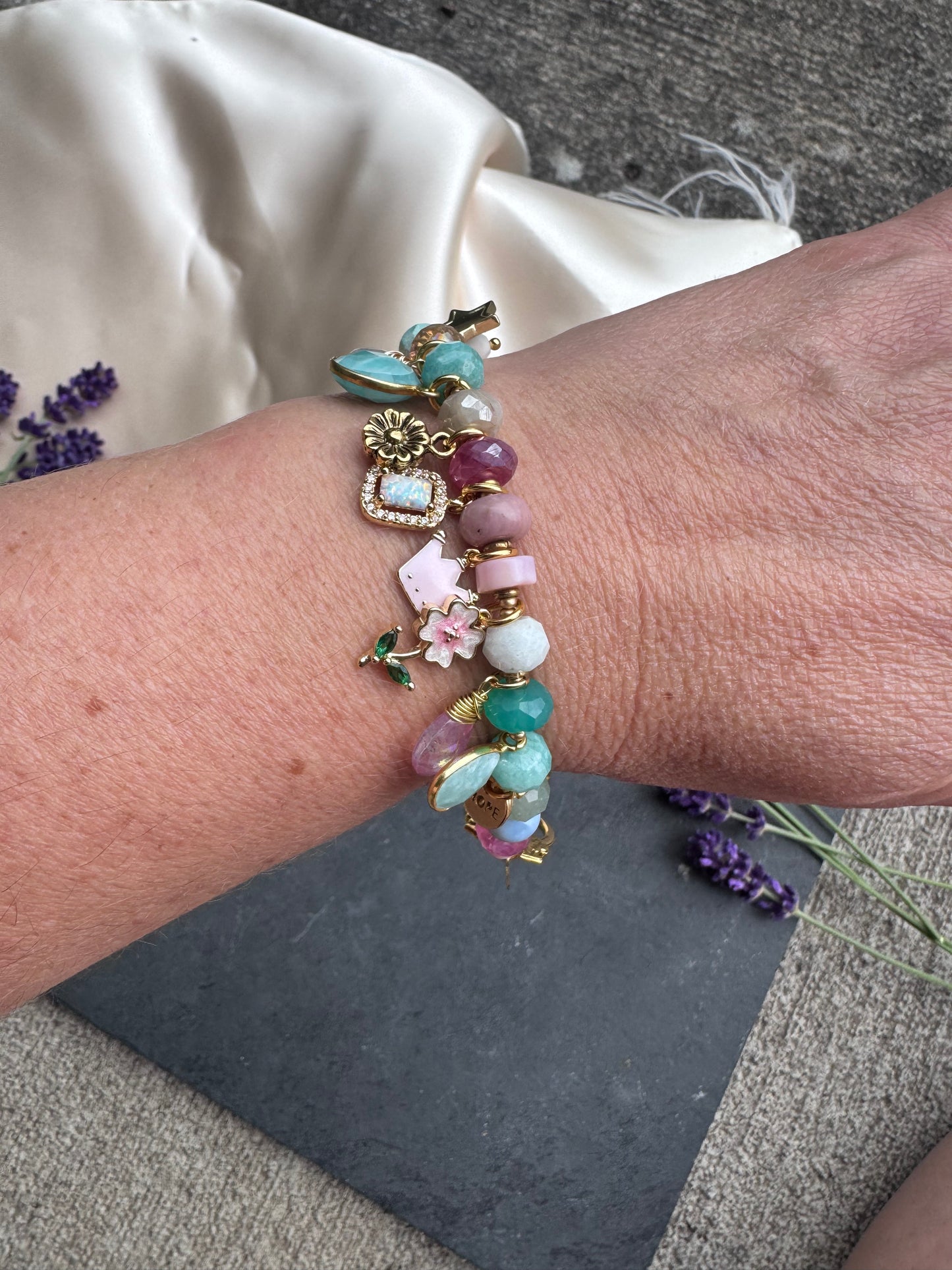 Charm pastel bracelet. Mixed gemstone, charms and gold metal bracelet.