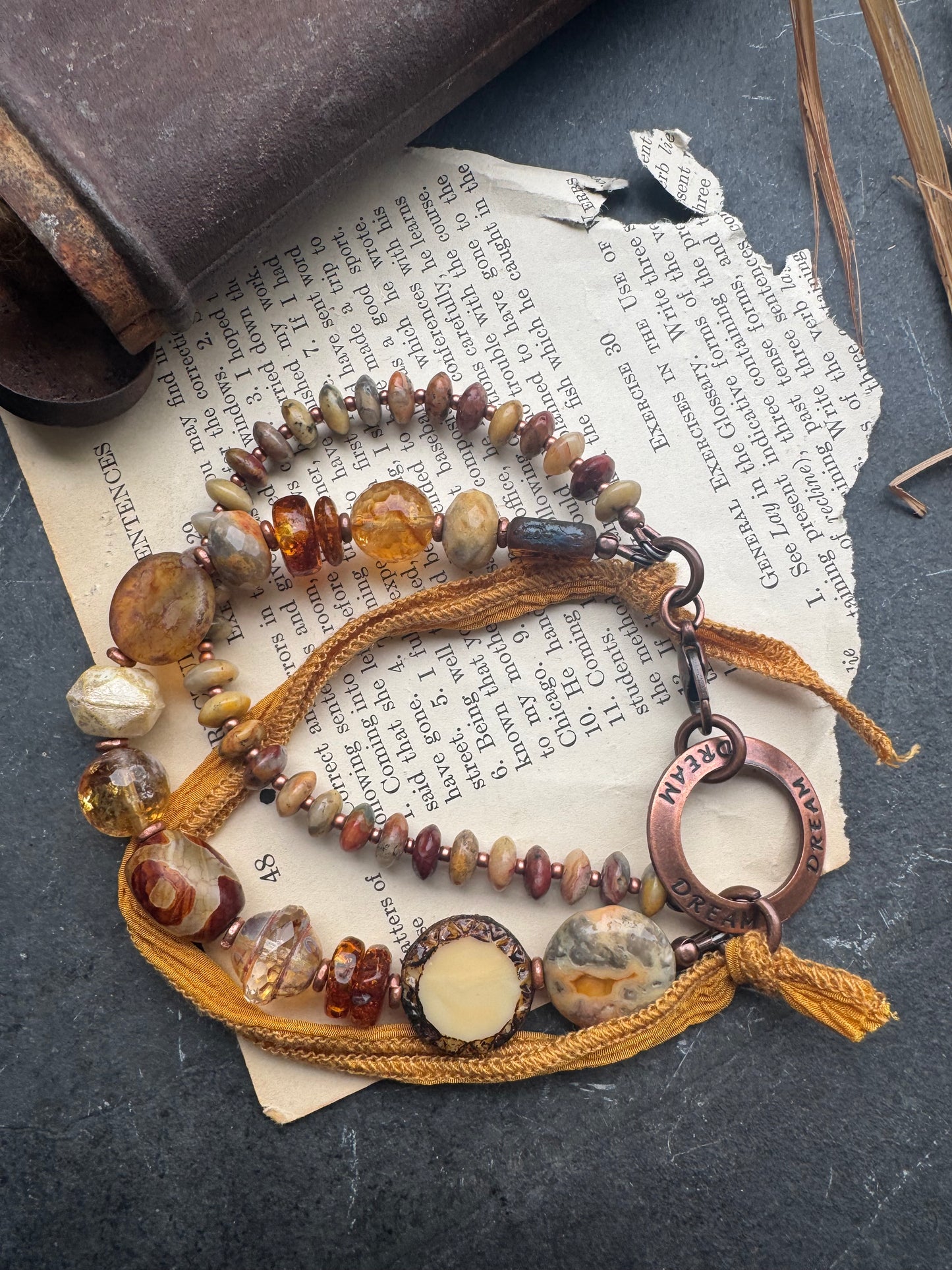 Amber, crazy lace agate, citrine, Czech glass, silk ribbon, copper, bracelet. Message ring says dream.