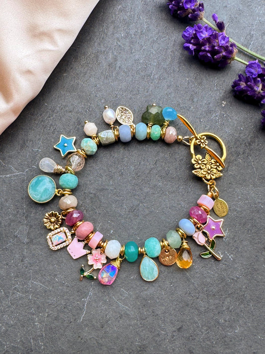 Charm pastel bracelet. Mixed gemstone, charms and gold metal bracelet.