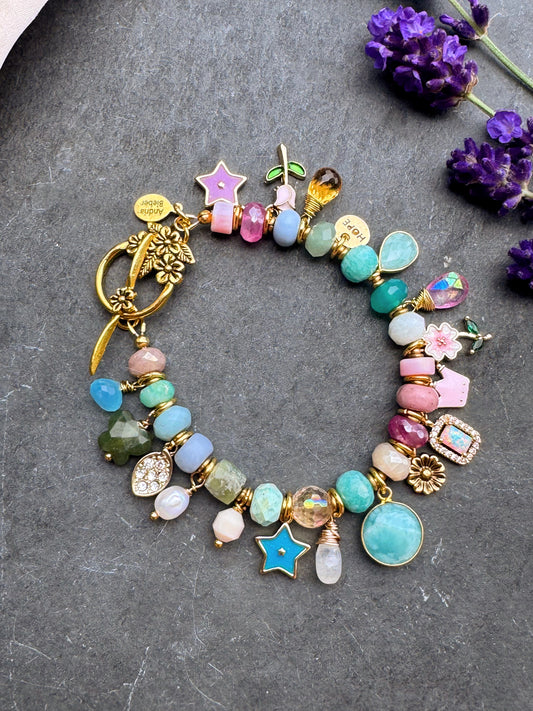 Charm pastel bracelet. Mixed gemstone, charms and gold metal bracelet.