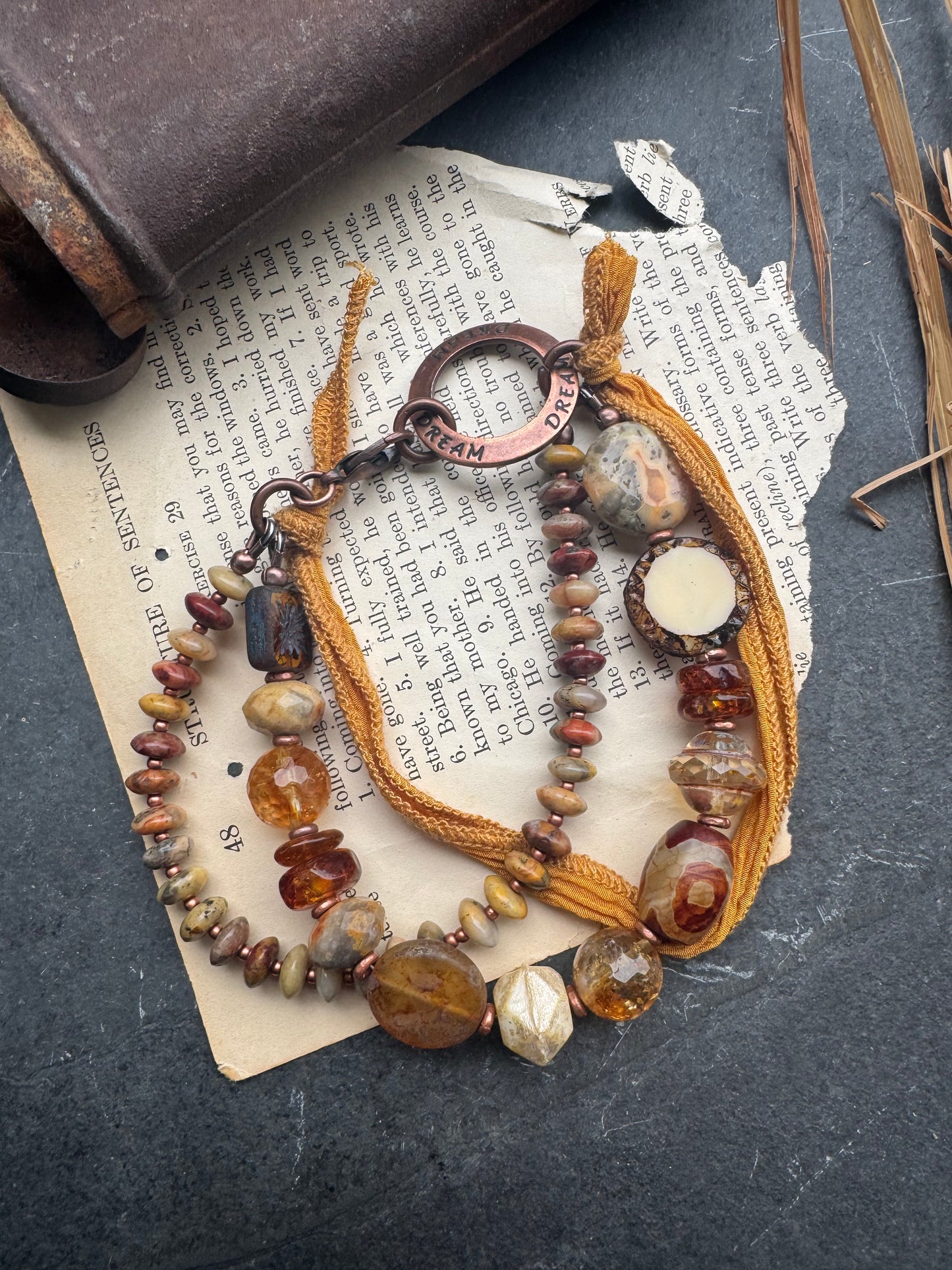 Amber, crazy lace agate, citrine, Czech glass, silk ribbon, copper, bracelet. Message ring says dream.