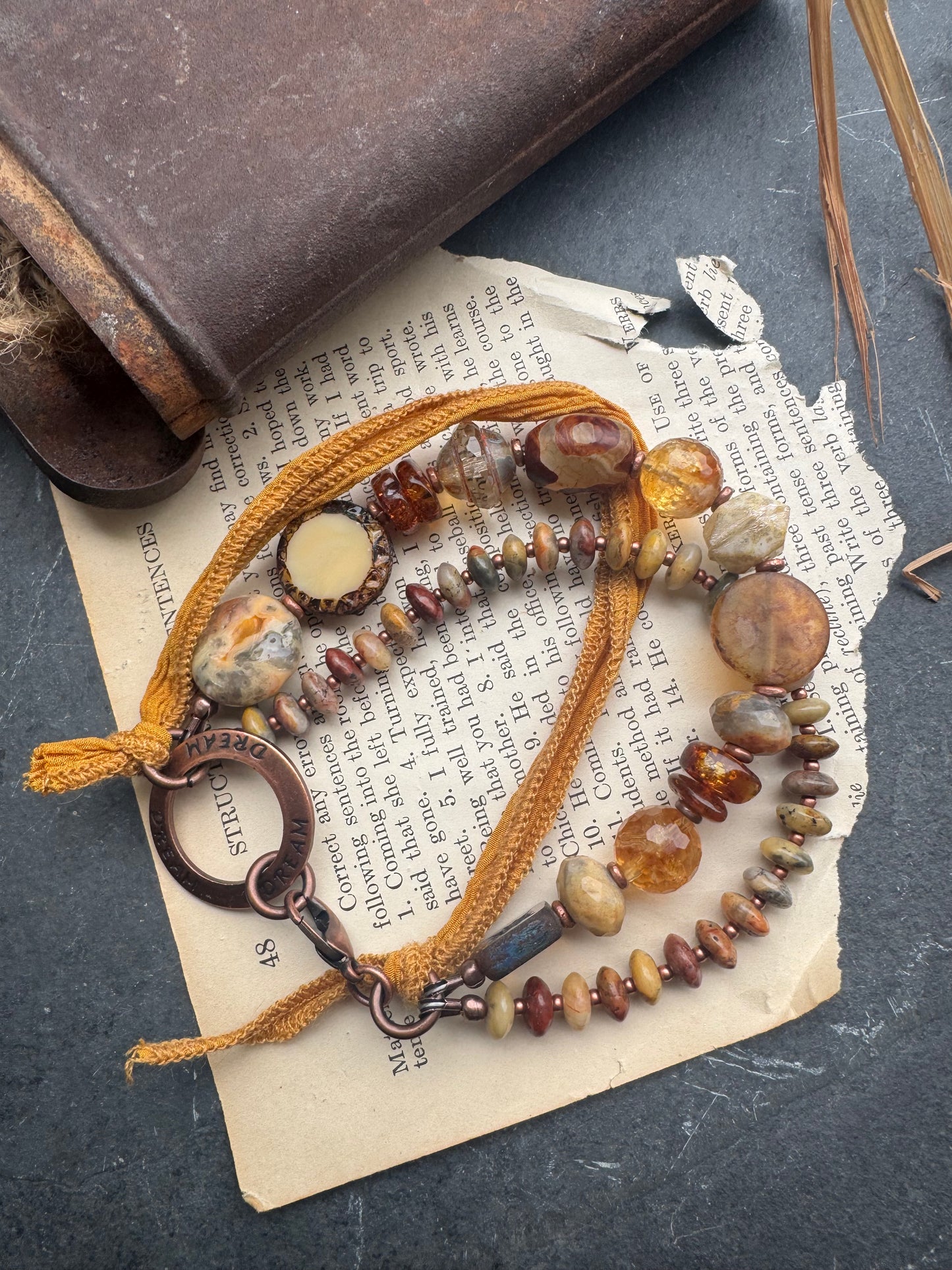 Amber, crazy lace agate, citrine, Czech glass, silk ribbon, copper, bracelet. Message ring says dream.