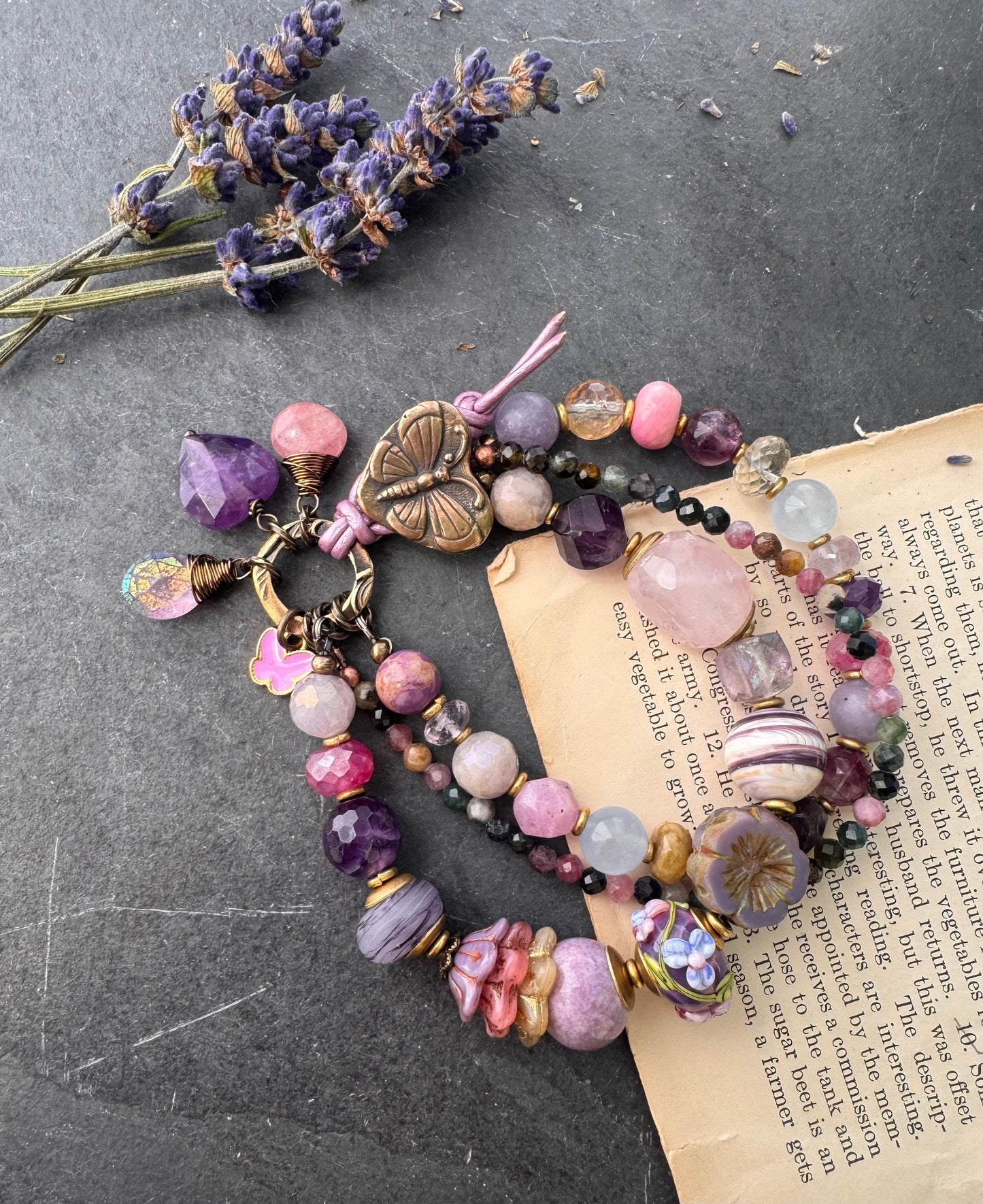 Handmade lampwork glass, mixed gemstone, ceramic, Czech Glass and butterfly button button. Purple leather closure.