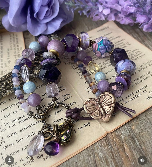 lampwork glass, 
Purple Stichtite, aquamarine, faceted green amethyst, fluorite stone, purple oyster, and bronze butterfly metal button.