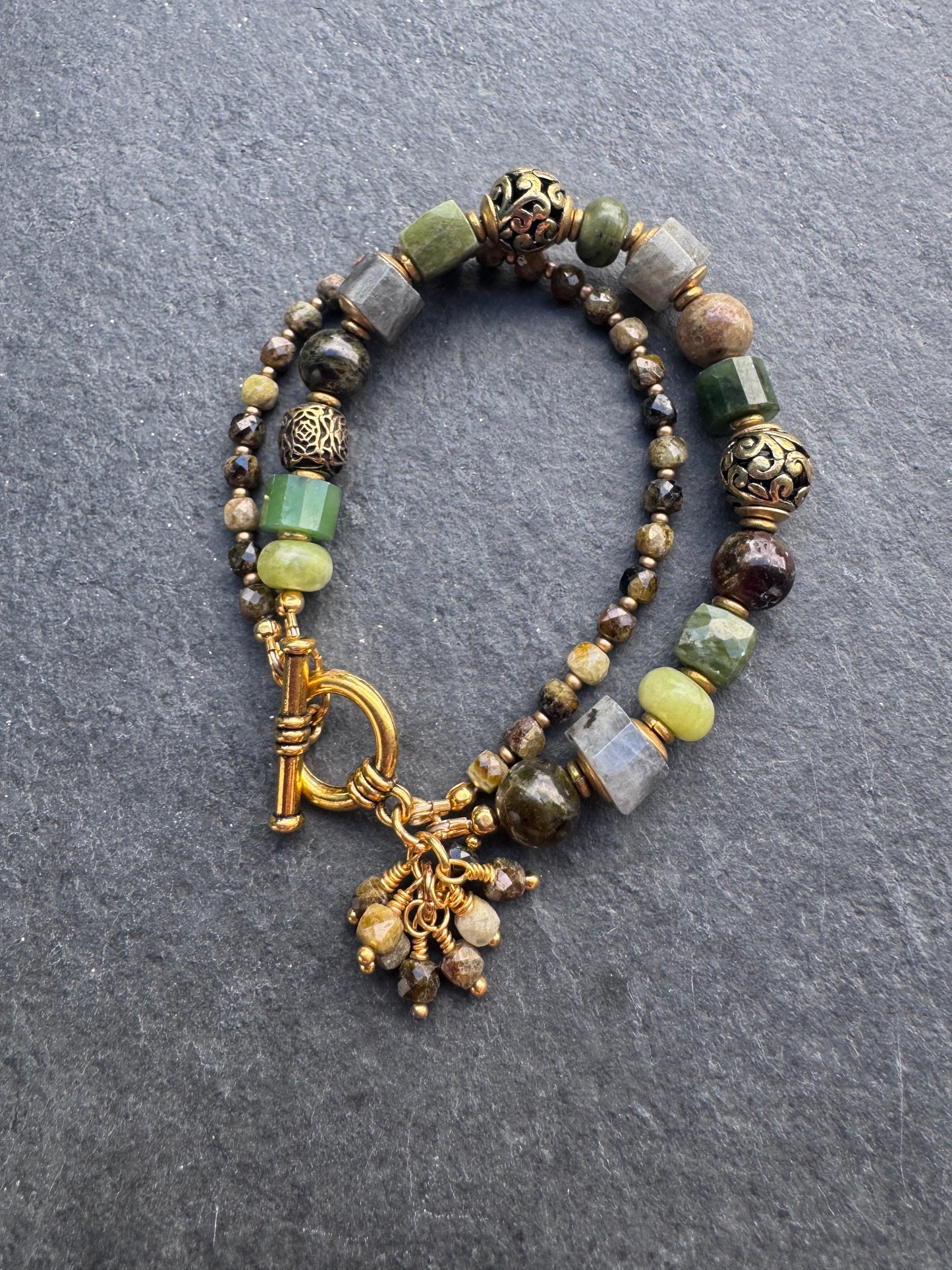 Green garnet, labradorite, jade, and gold metal bracelet.