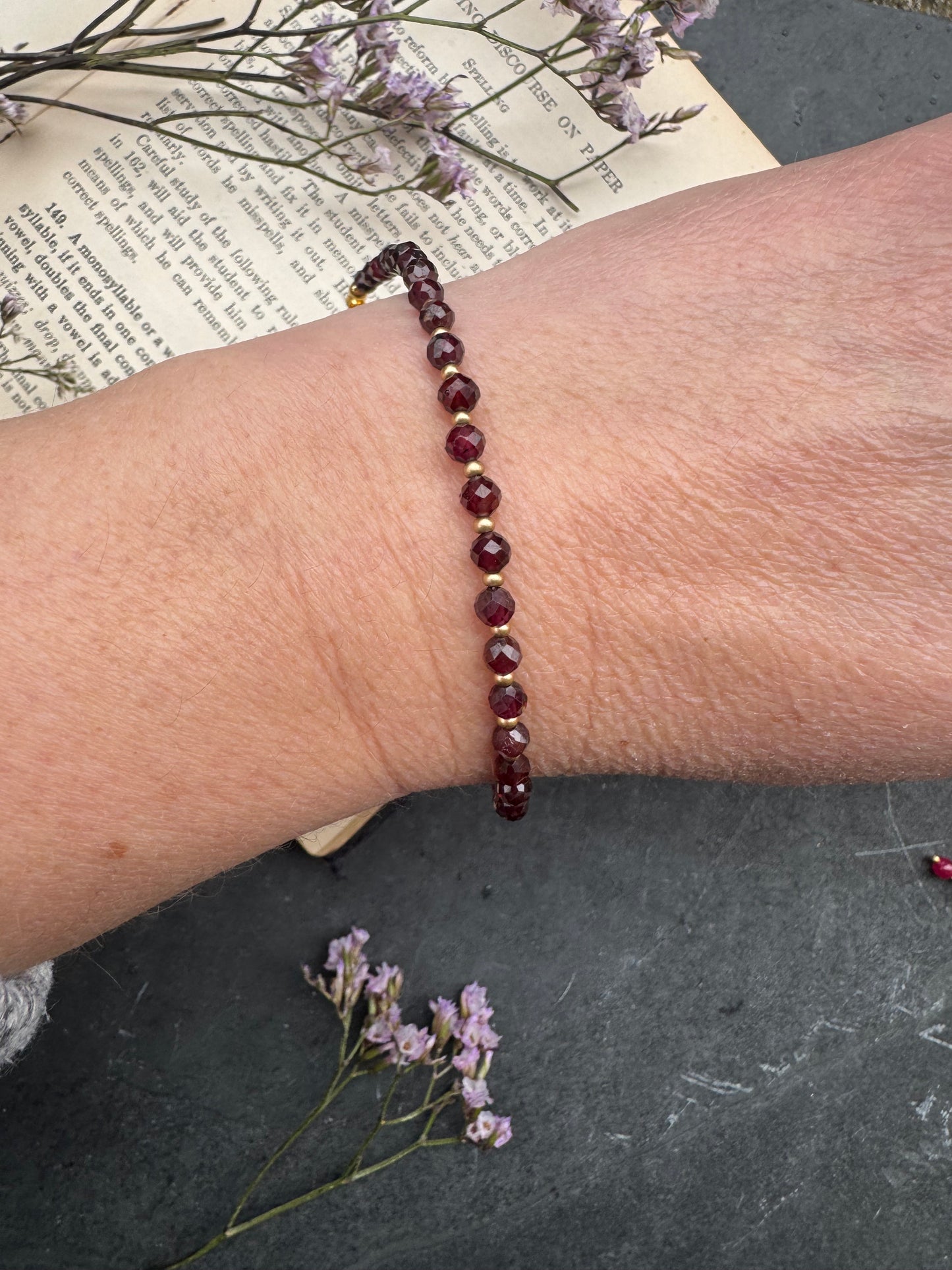 Garnet (January birthstone) faceted round stone, gold metal, bracelet