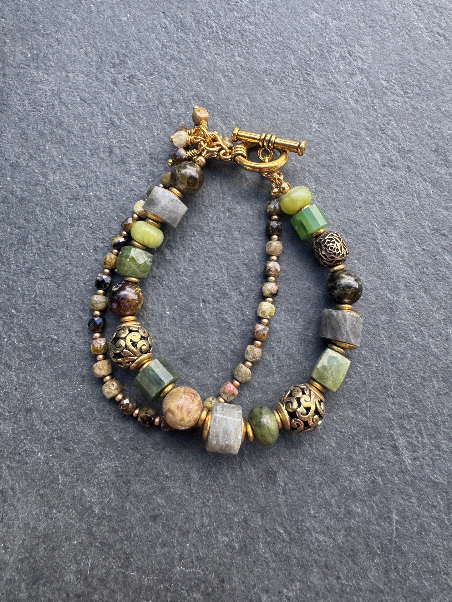 Green garnet, labradorite, jade, and gold metal bracelet.