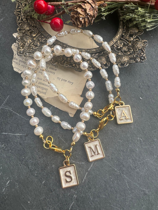 Pearl (freshwater) and initial charm bracelet. Gold and pearlescent letter charm.